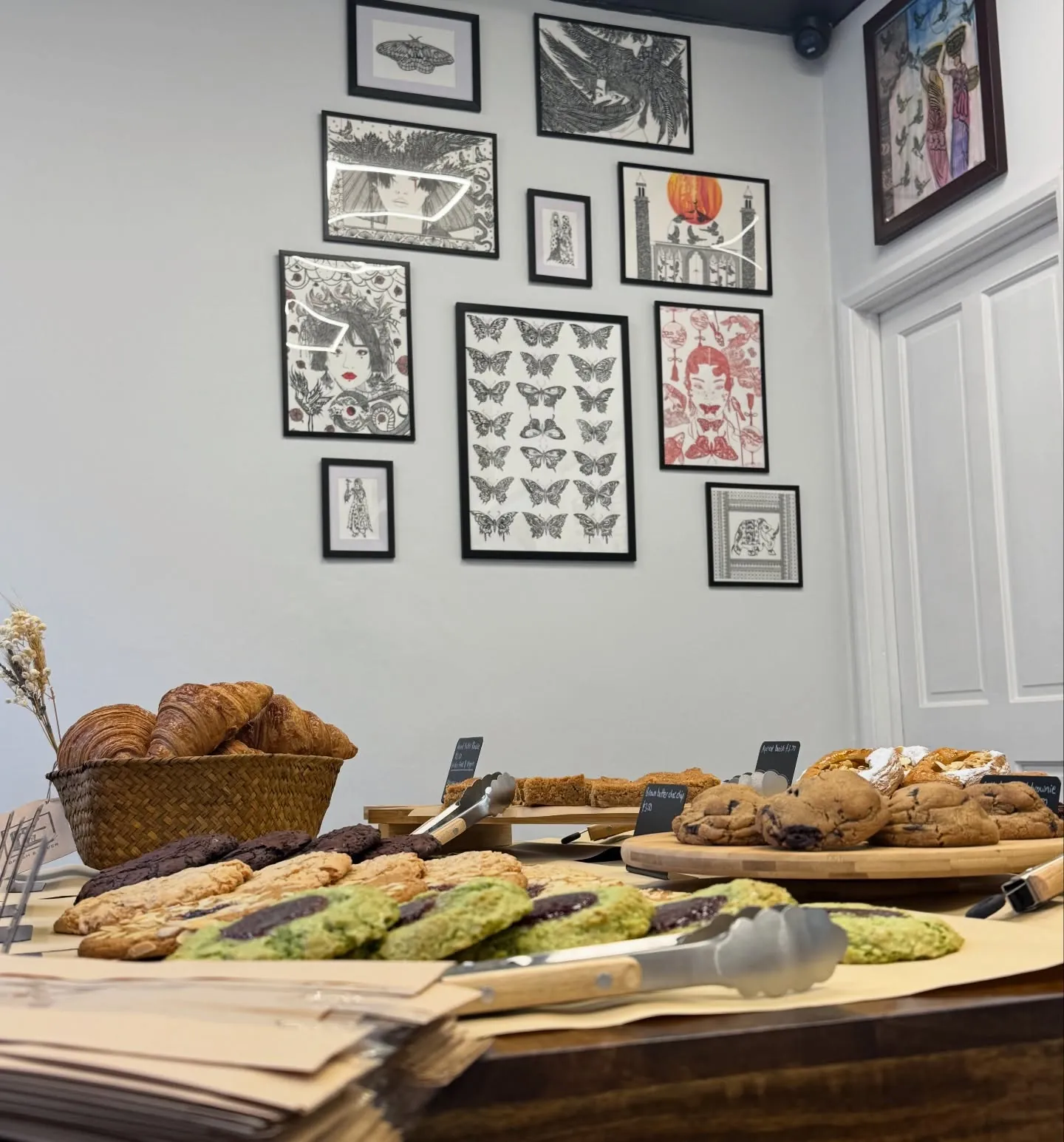 The bake table beneath a wall of framed prints